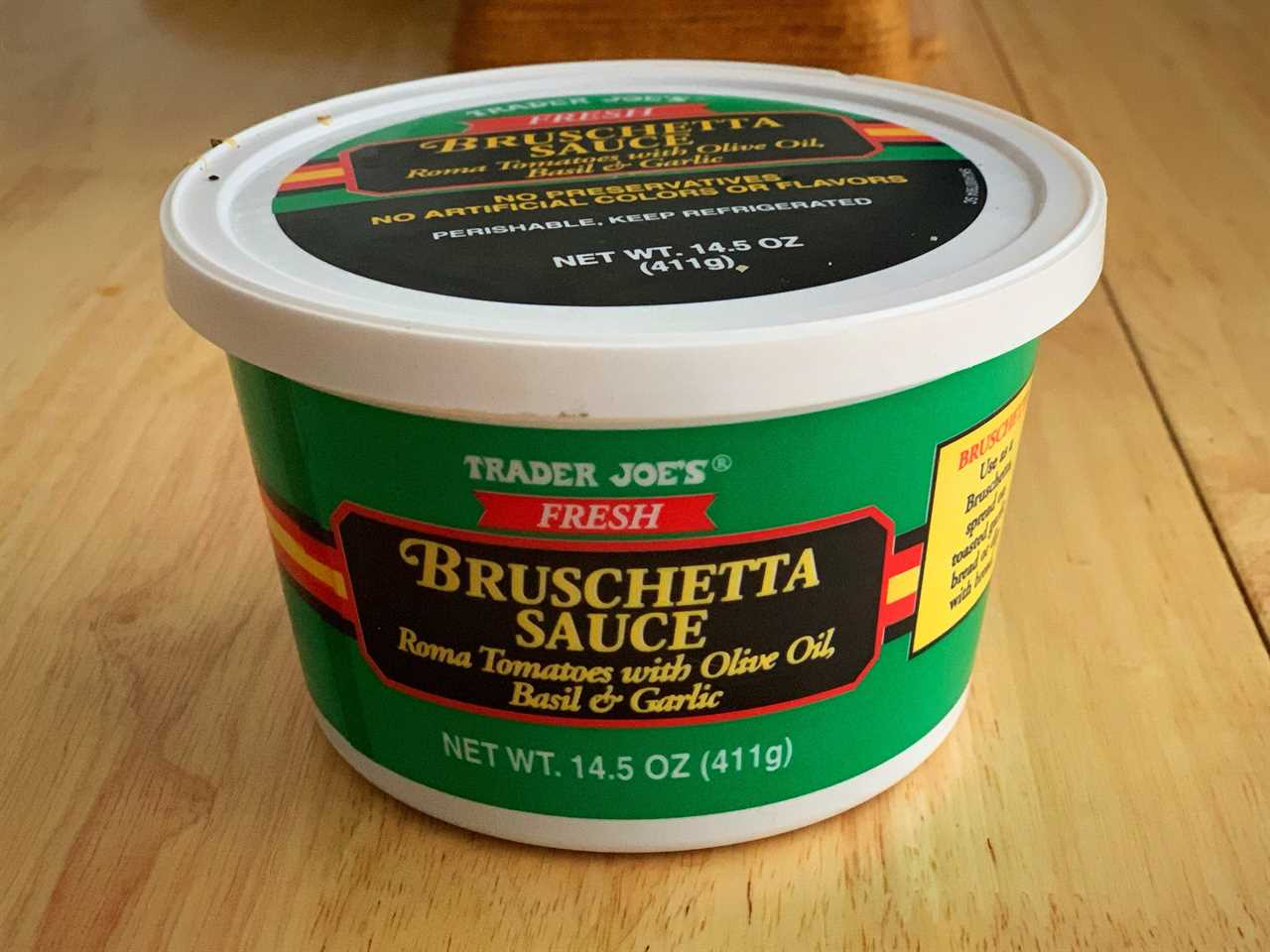 green and black tub of trader joe's bruschette sauce on wood table