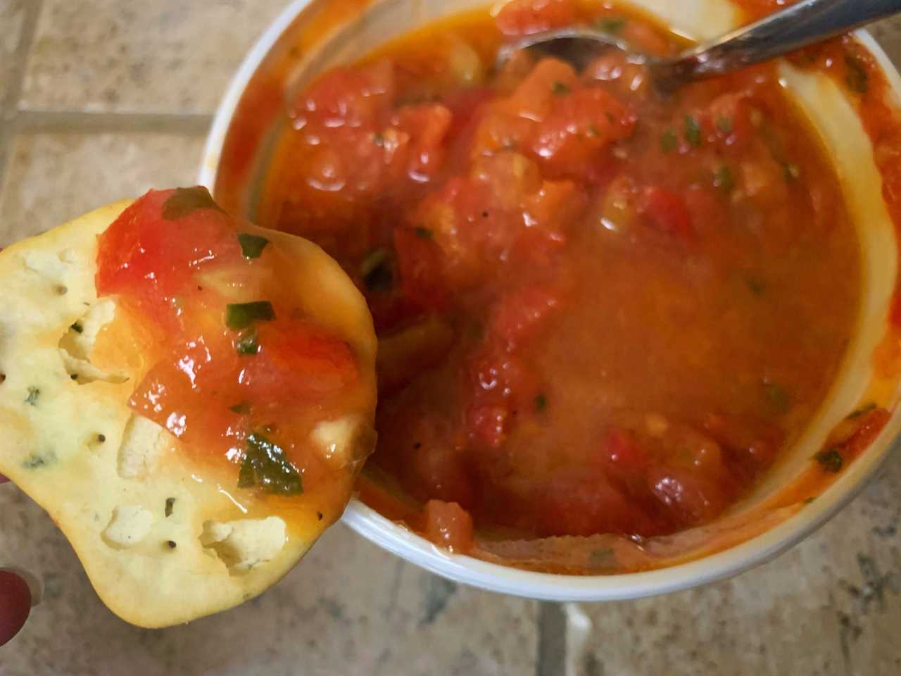 chip dipping in trader joe's bruschetta sauce