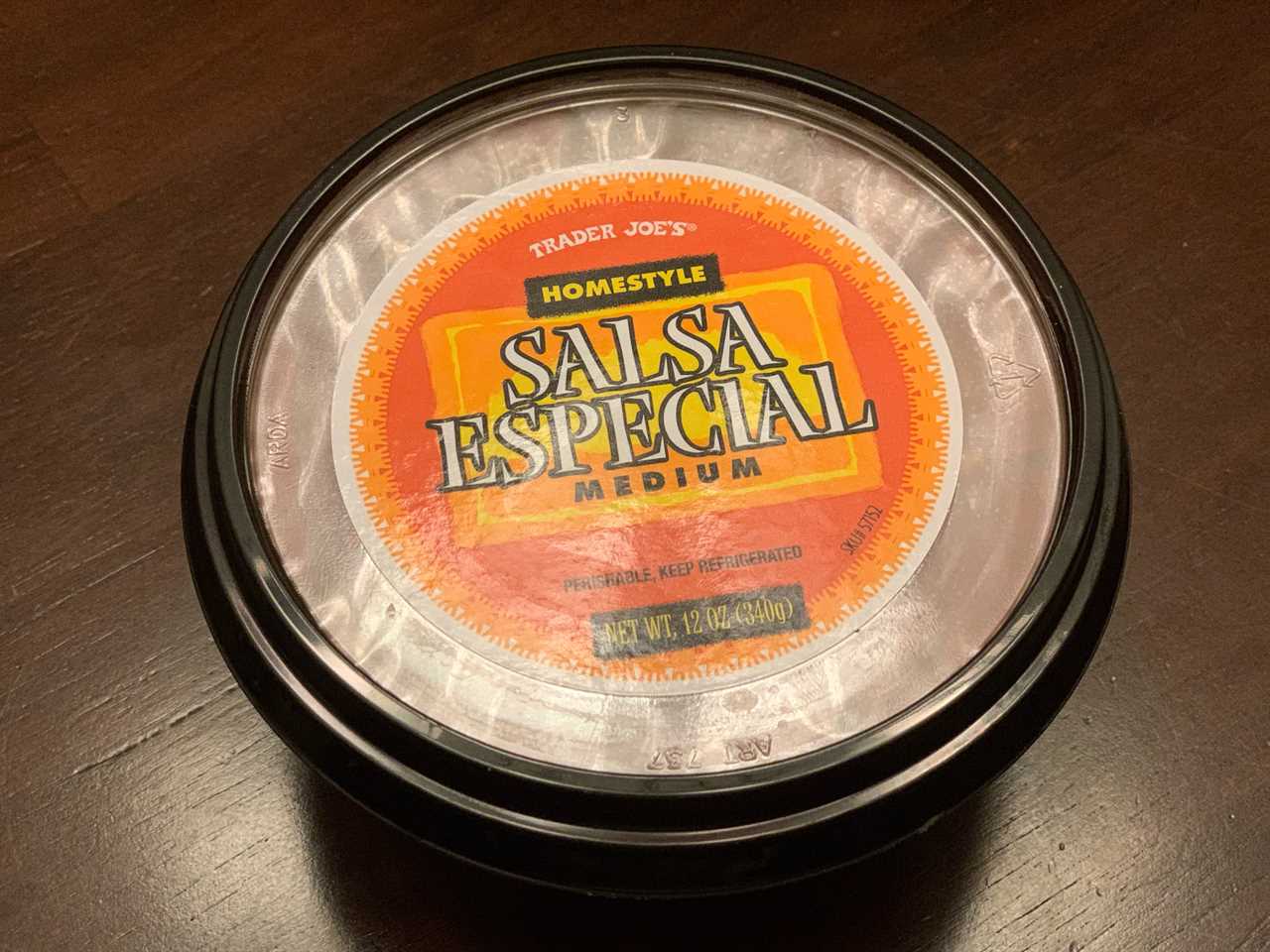 black and orange tub of trader joe's salsa especial on wood table