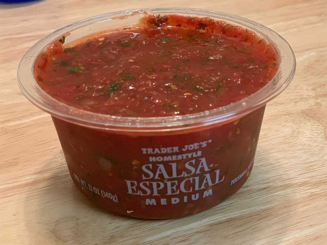 red tub of trader joe's salsa especial on wood table