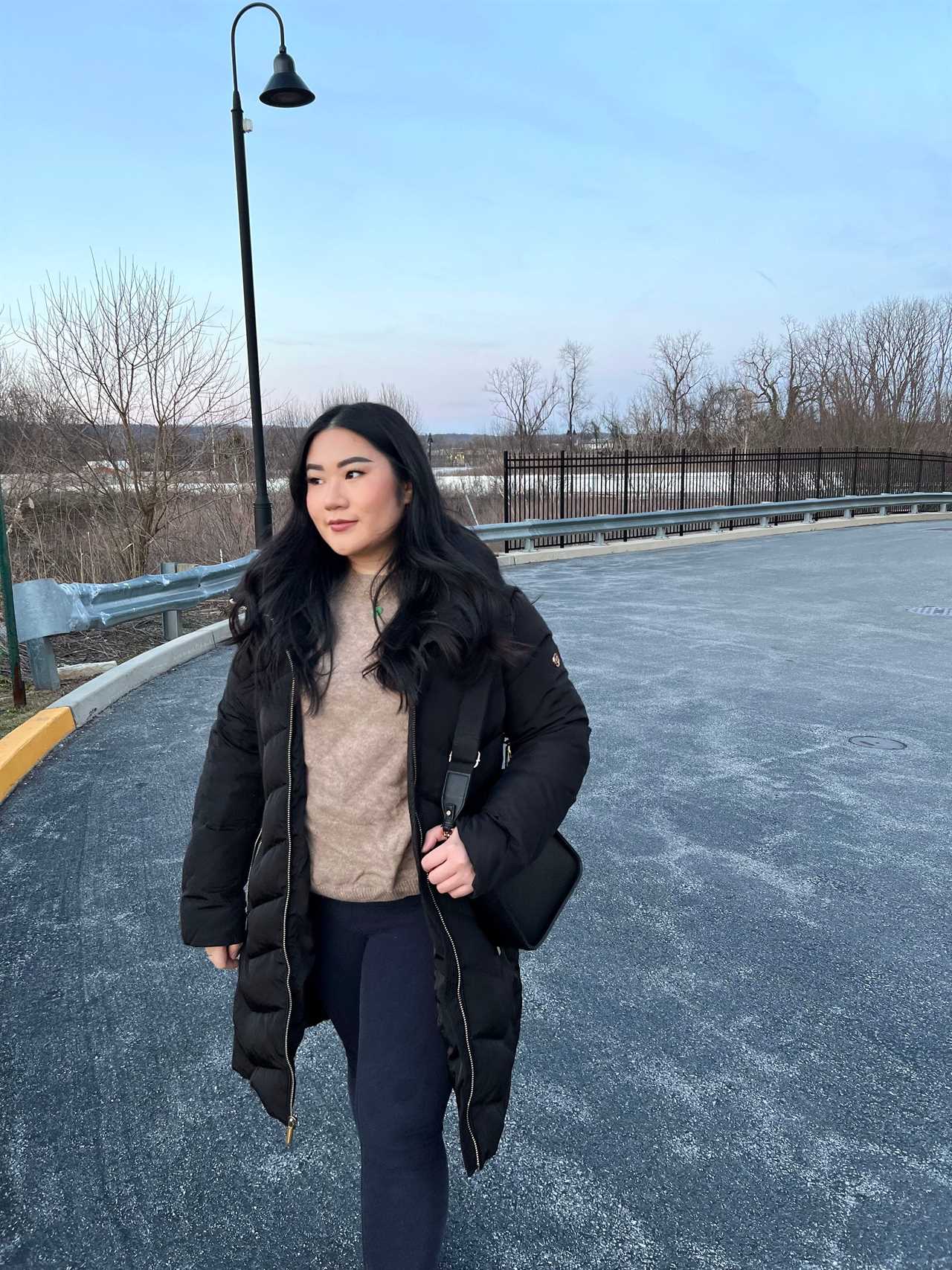 Kelsey Lam wearing a black coat and standing outdoors during the daytime.