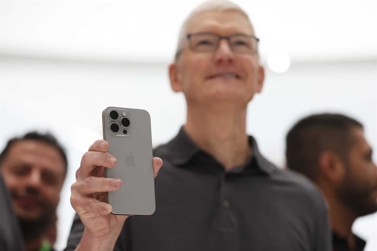 Tim Cook holding up the iphone 15