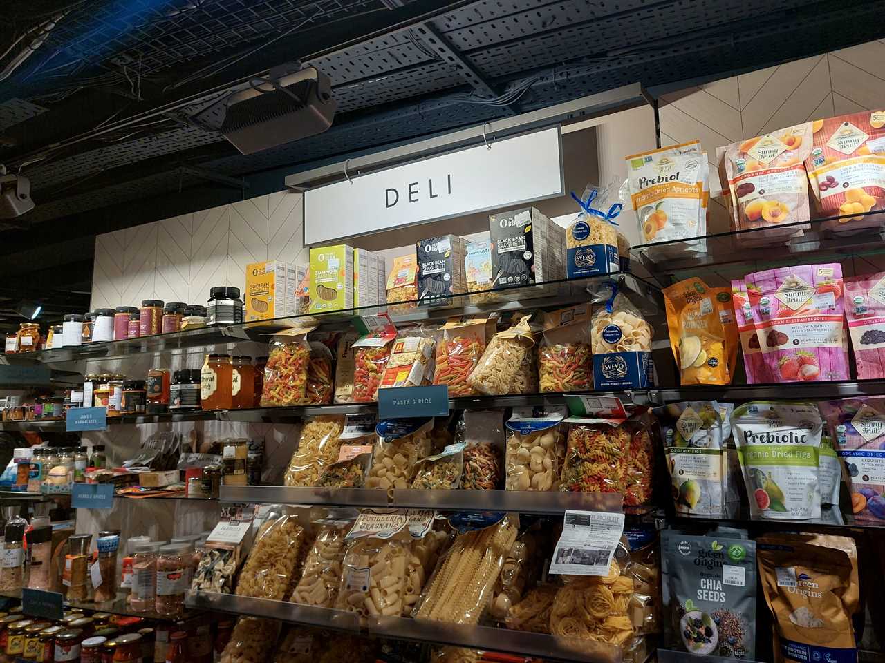 The deli display in a T.K. Maxx store in London showing shelves of seeds, dried fruit, pasta, and rice.