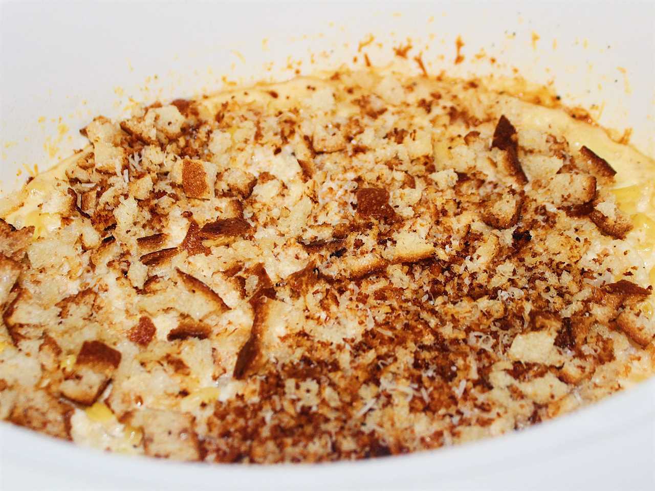 cooked mac and cheese in slow cooker topped with breadcrumbs