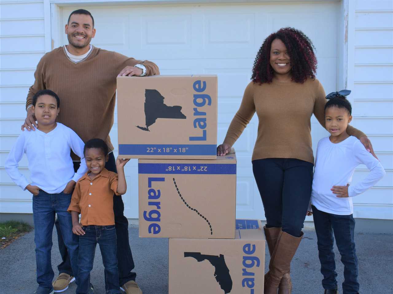 a family poses with moving boxes