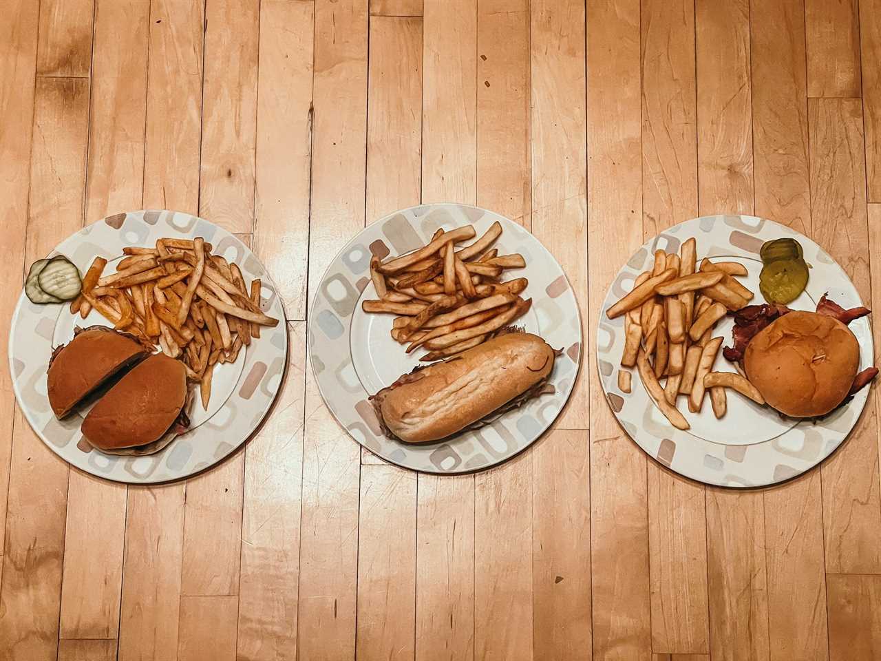 three plates of pulled pork sandwiches with french fries