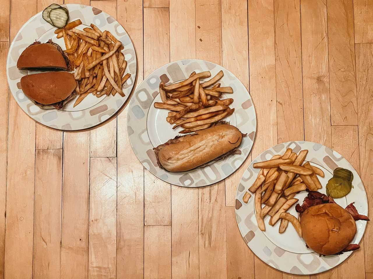 three plates of pulled pork sandwiches with a side of french fries