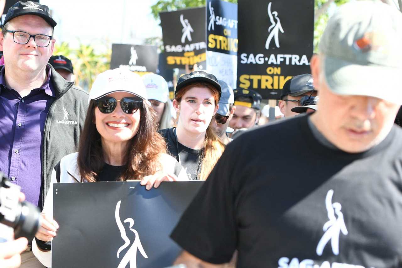 Actors on strike in SAG-AFTRA strike holding picket signs