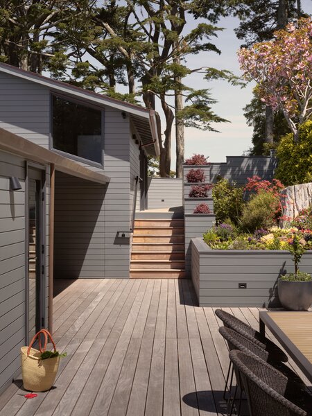 Stairs lead from the street to the decked entry garden, where Roberta grows herbs she cooks with. The glass door leads into the kitchen. A Koko dining table and Gigi dining chairs are from Janus et Cie.