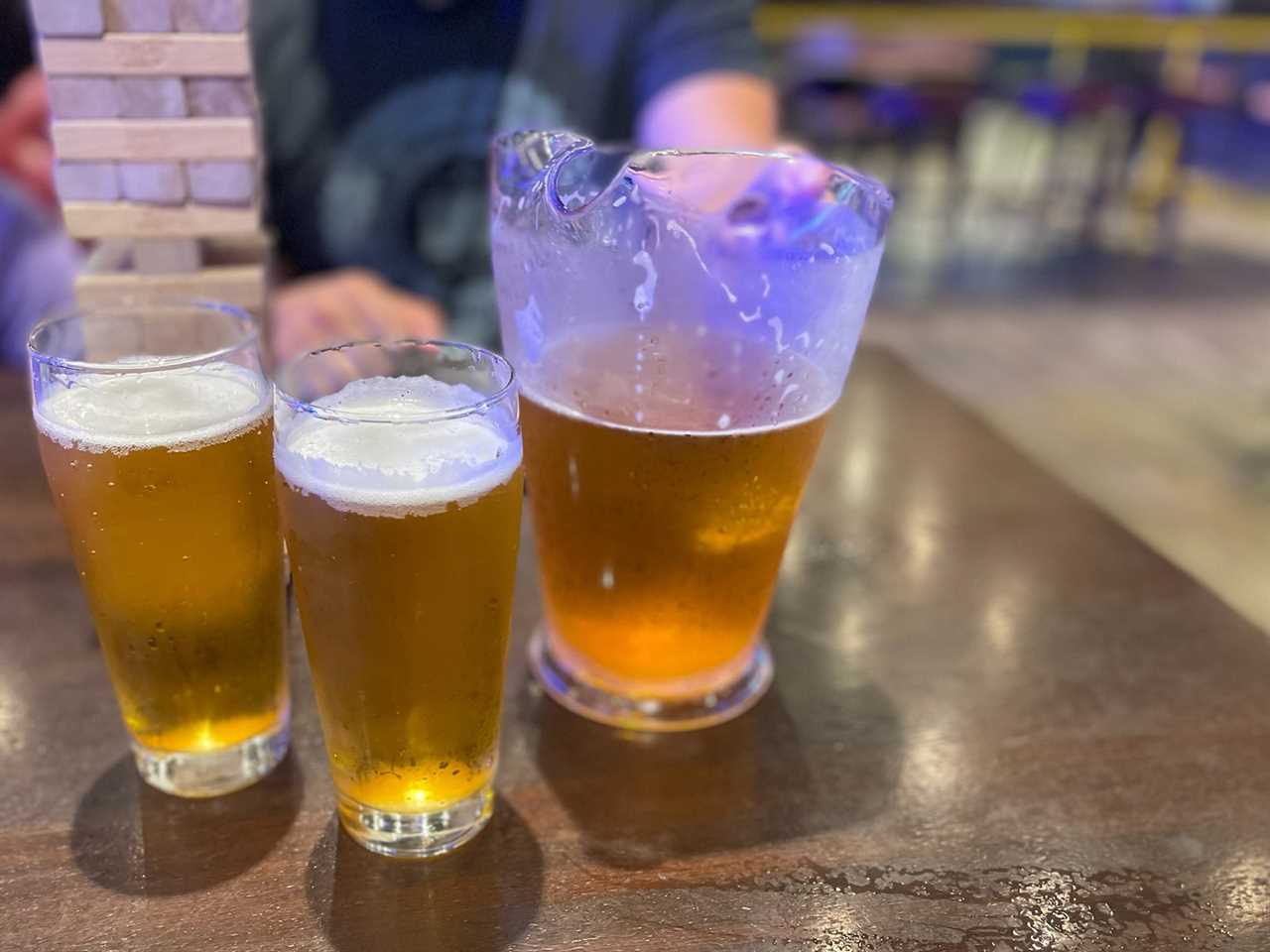 one pitcher of beer and two glasses on table