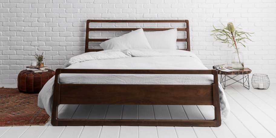 A bed made up with the Parachute Venice Linen Sheets set up in a bedroom.