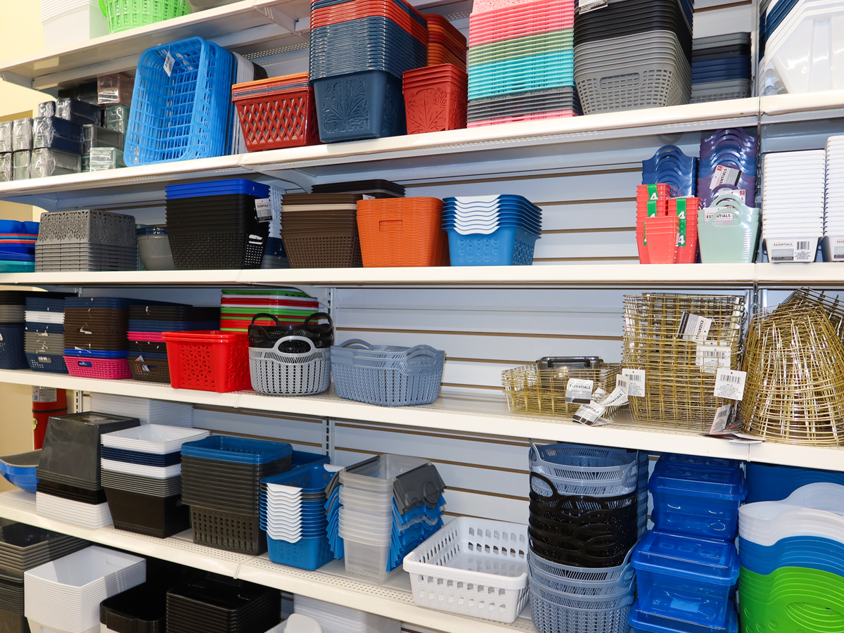 Shelves of plastic bins at Dollar Tree. Bins come in gray, blue, orange, red, and metallic colors