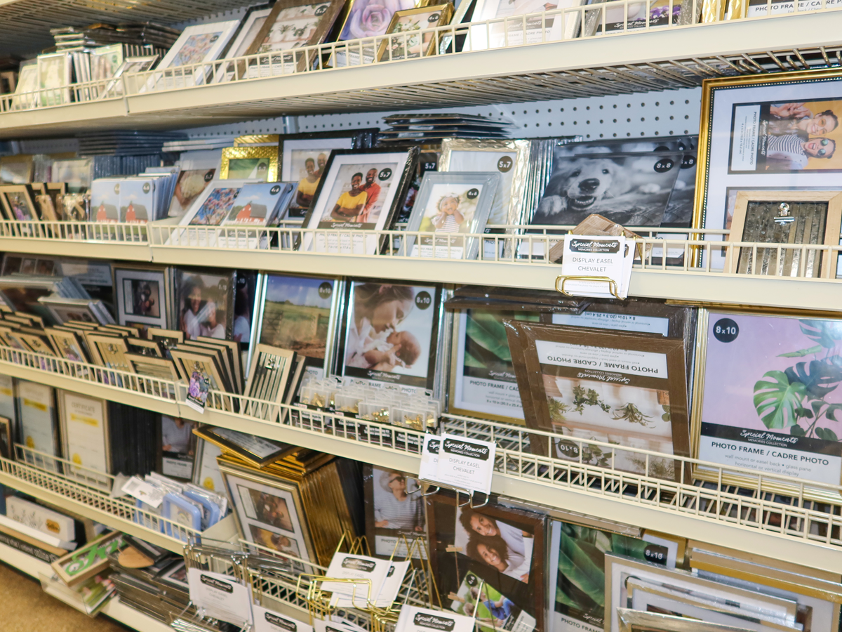 Shelves of picture frames at Dollar Tree. Some frames are made from faux wood and some are gold