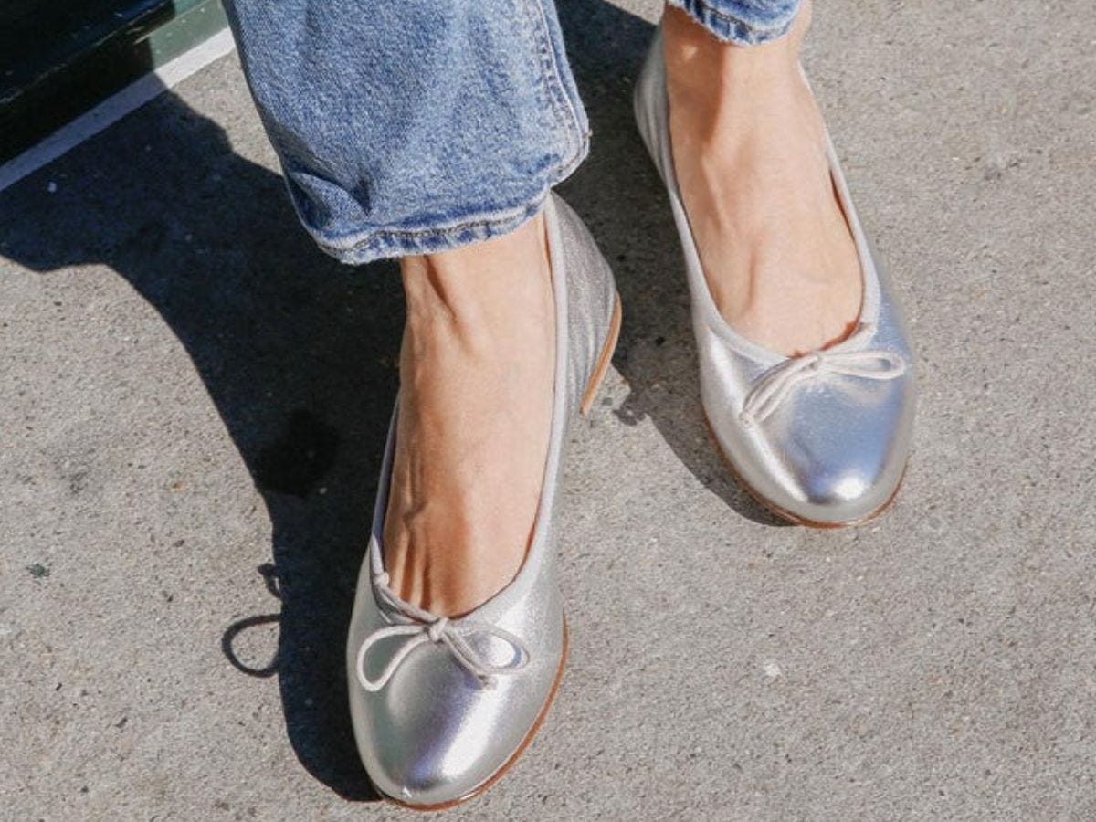 Silver ballet flats on model.