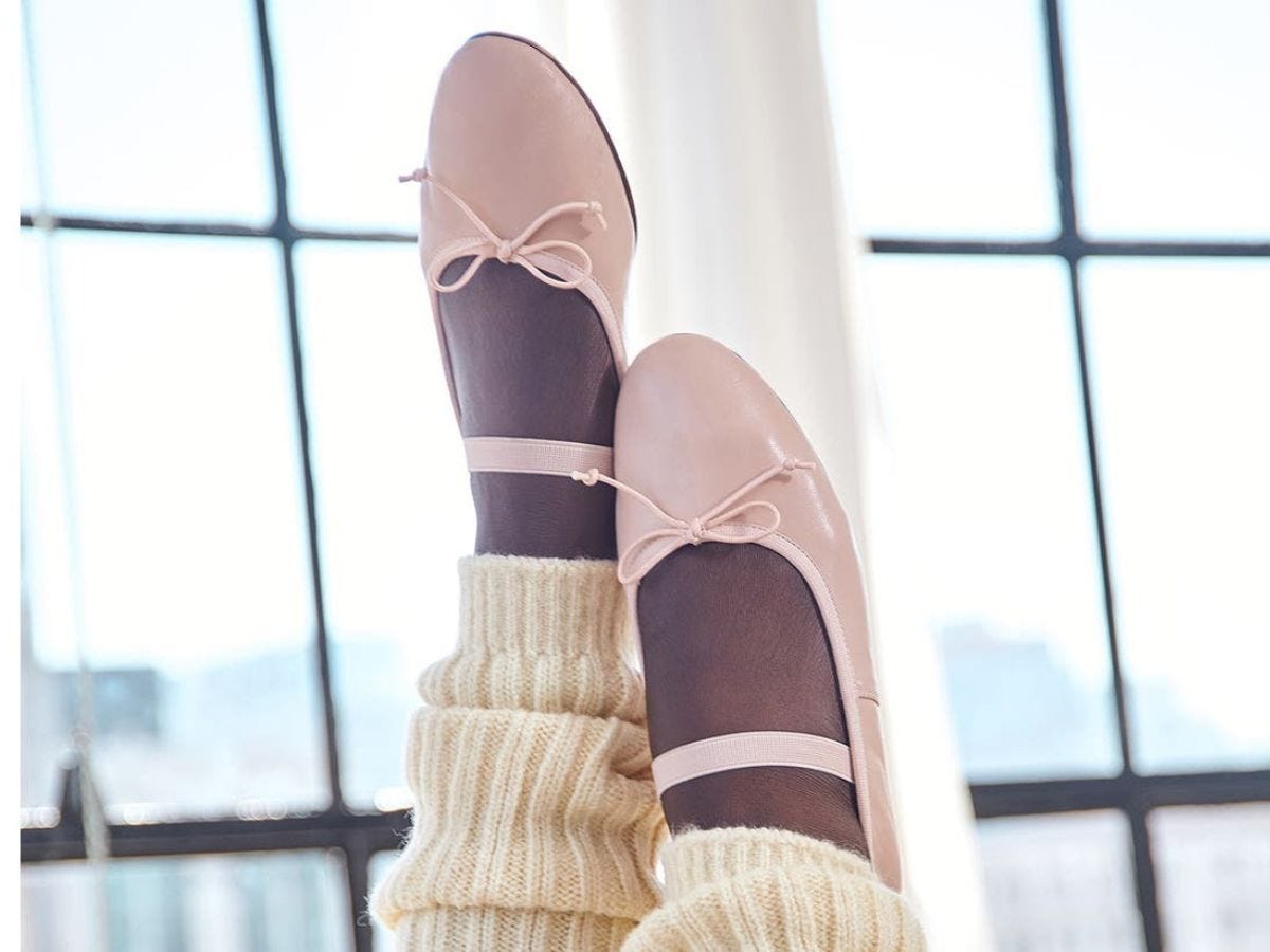 Pale pink Chinese Laundry Audrey Mary Jane ballet flats worn with white leg warmers on model.