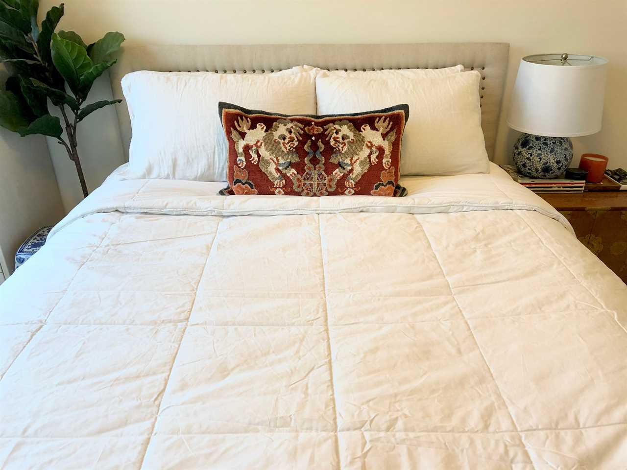 A Brooklinen weighted comforter on a nicely made bed, one of the best weighted blankets in 2022.