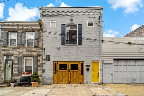 Upon arrival, a bright yellow door extends a warm welcome. The custom wood doors open to create a breezy outdoor extension for summer entertaining.