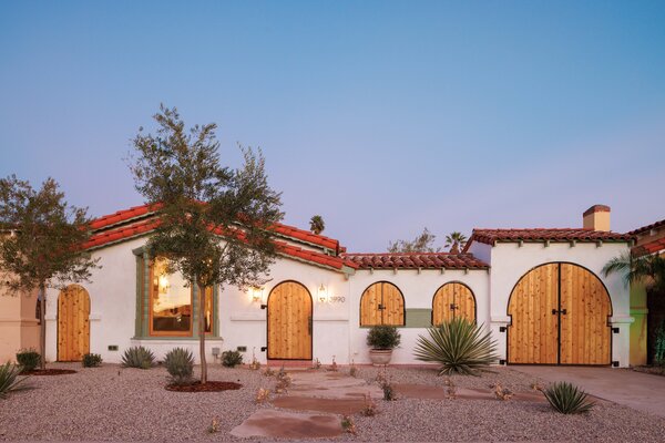 Rustic colored Spanish tiles line the roof of the one-level home, while wooden doors and window coverings allow for ample privacy.