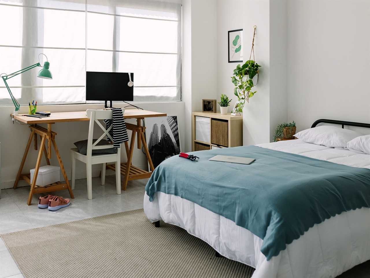 clean modern bedroom with a desk and a bed and blue and white design details