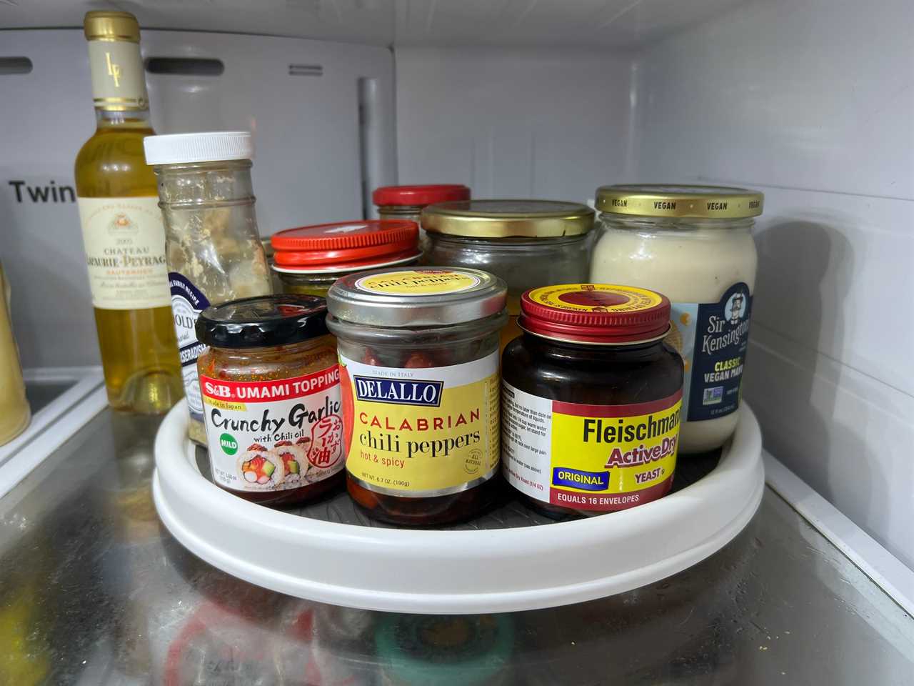 The OXO lazy susan in a fridge with condiments on it for a review of the OXO lazy susan in 2022.