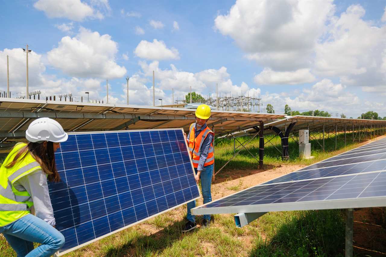 Two engineers bring the solar panel for installation at the solar farm.