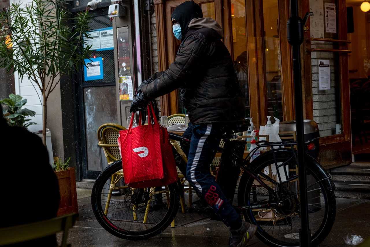 A DoorDash delivery driver riding a bicycle