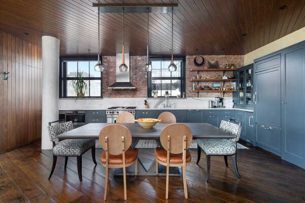 The airy kitchen comes with long countertops, custom cabinetry, and bespoke appliances.