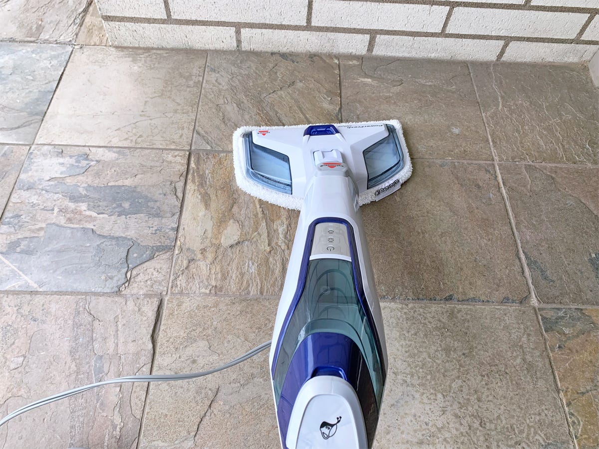 The Bissell 1806 PowerFresh Deluxe Steam Mop is cleaning a stone-tiled floor.