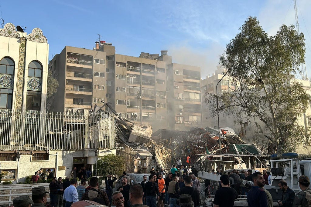 Emergency and security personnel gather at the site of strikes which hit a building next to the Iranian embassy in Syria's capital Damascus, on April 1, 2024.