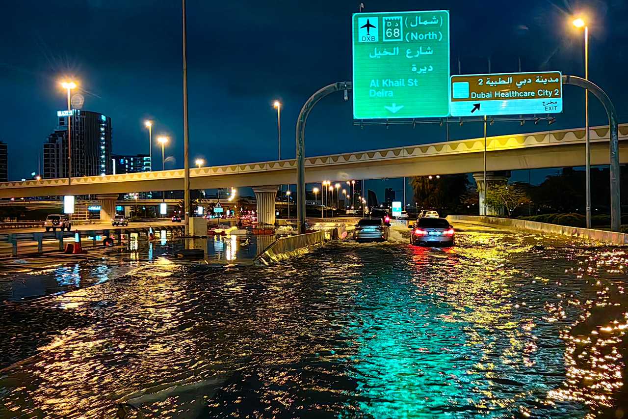Motorisits drive along a flooded street following heavy rains in Dubai early on April 17, 2024.
