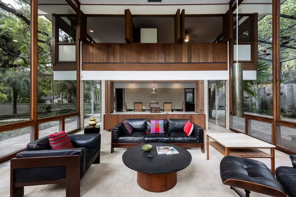 Wood-trimmed, floor-to-ceiling glazing wraps around the main living areas.