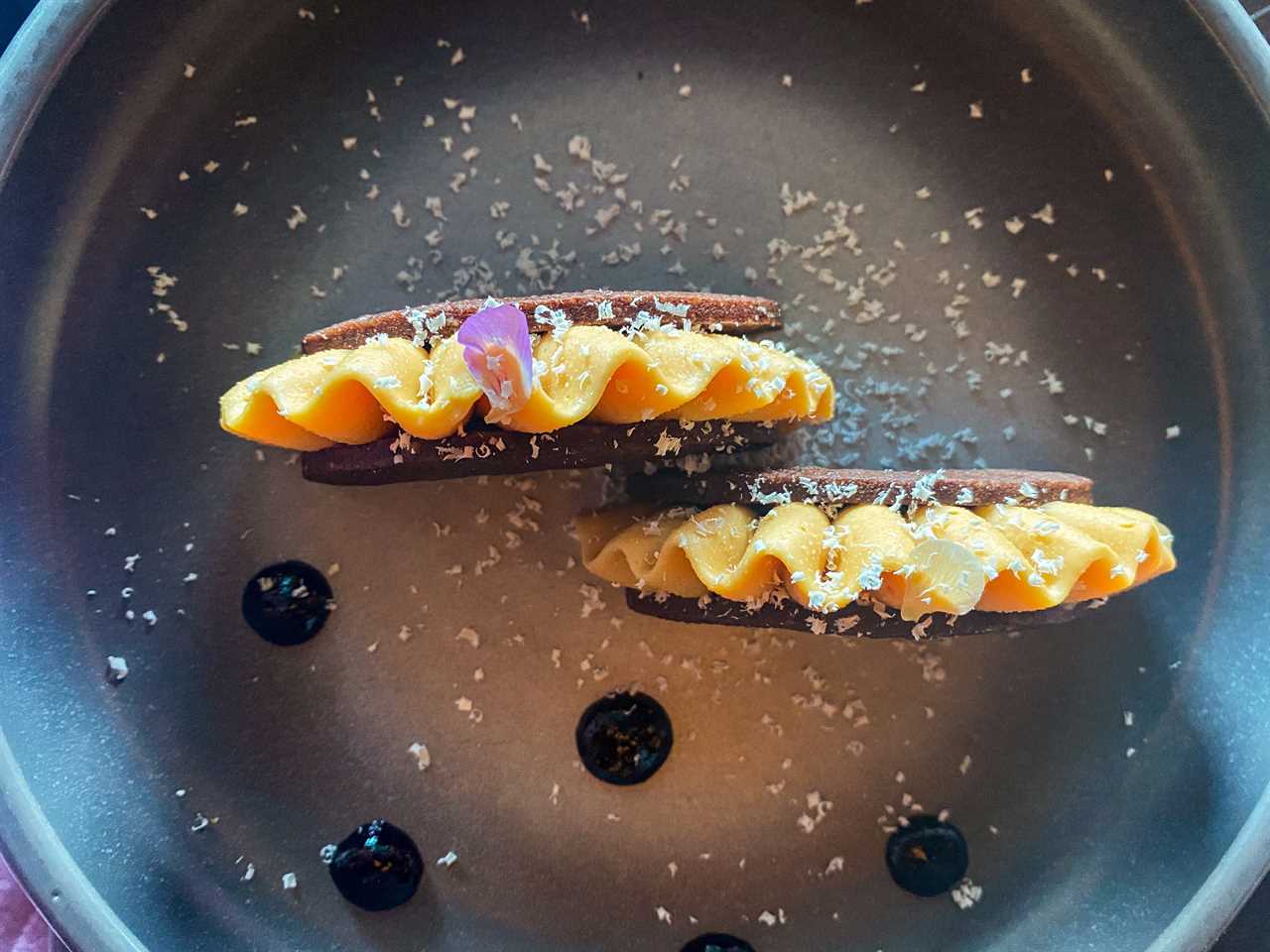 A chocolate taco desert dish on a black plate