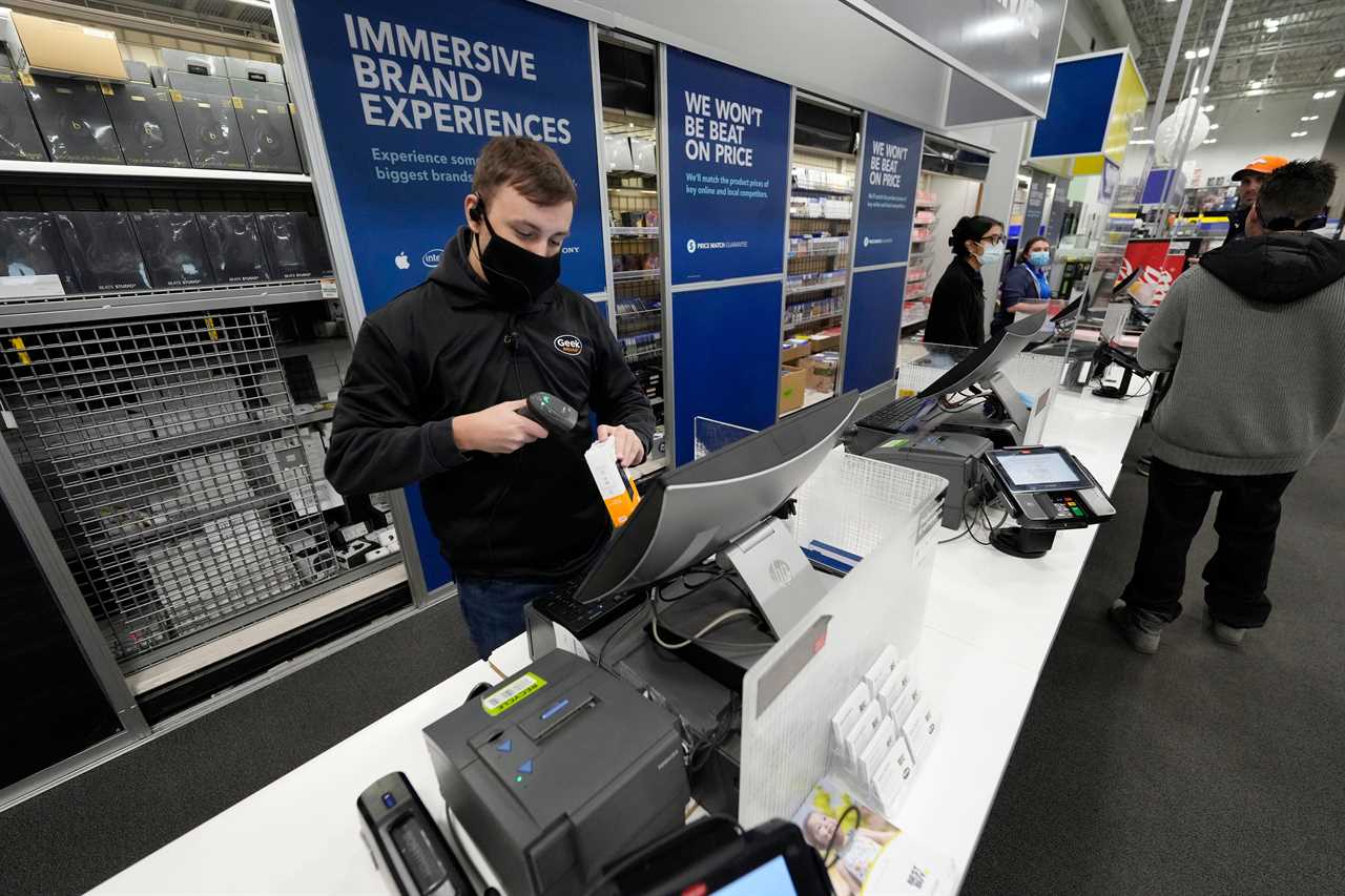 A sales associate processes the purchase of a hard drive at a Best Buy store after doors opened at 5 a.m. on Black Friday, Nov. 26, 2021, in Lone Tree, Colo. 