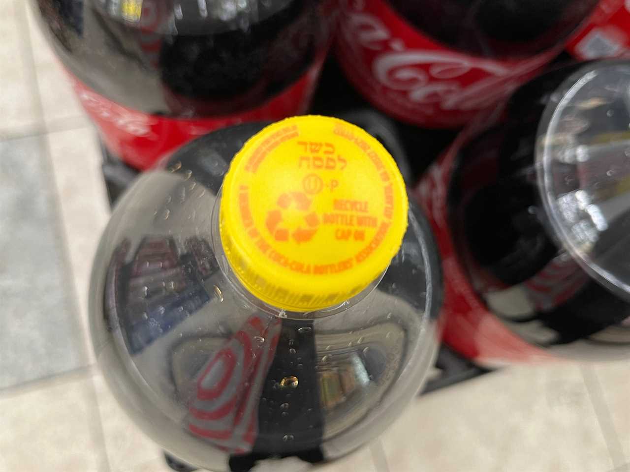 A yellow cap on a bottle of Coca-Cola, indicating that it's kosher for Passover.