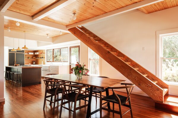 Exposed beams stretch across the main level, connecting the living areas and kitchen.