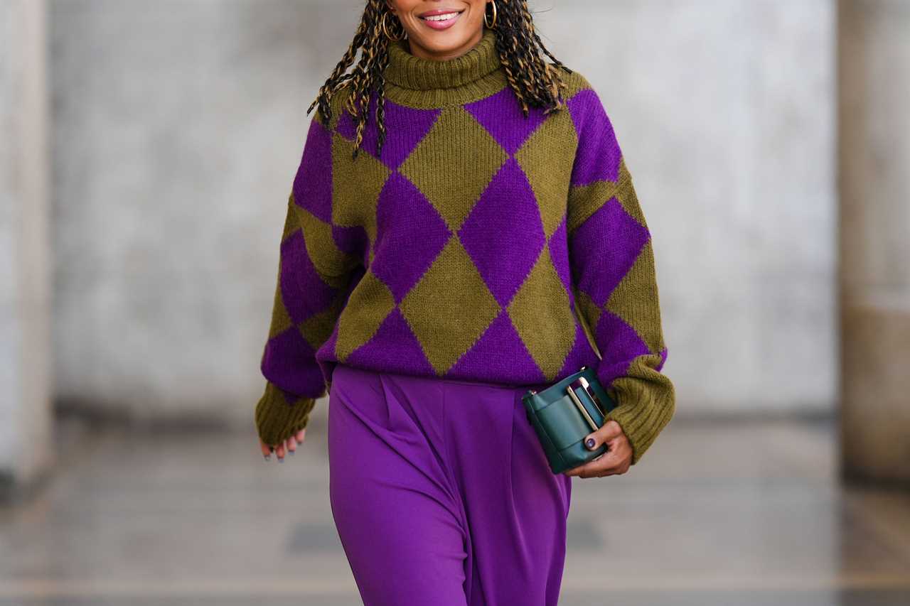 Woman wearing diamond-patterned purple and green sweater