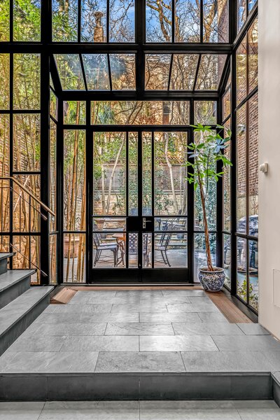 A double-height glass atrium connects the chef's kitchen with the landscaped backyard.