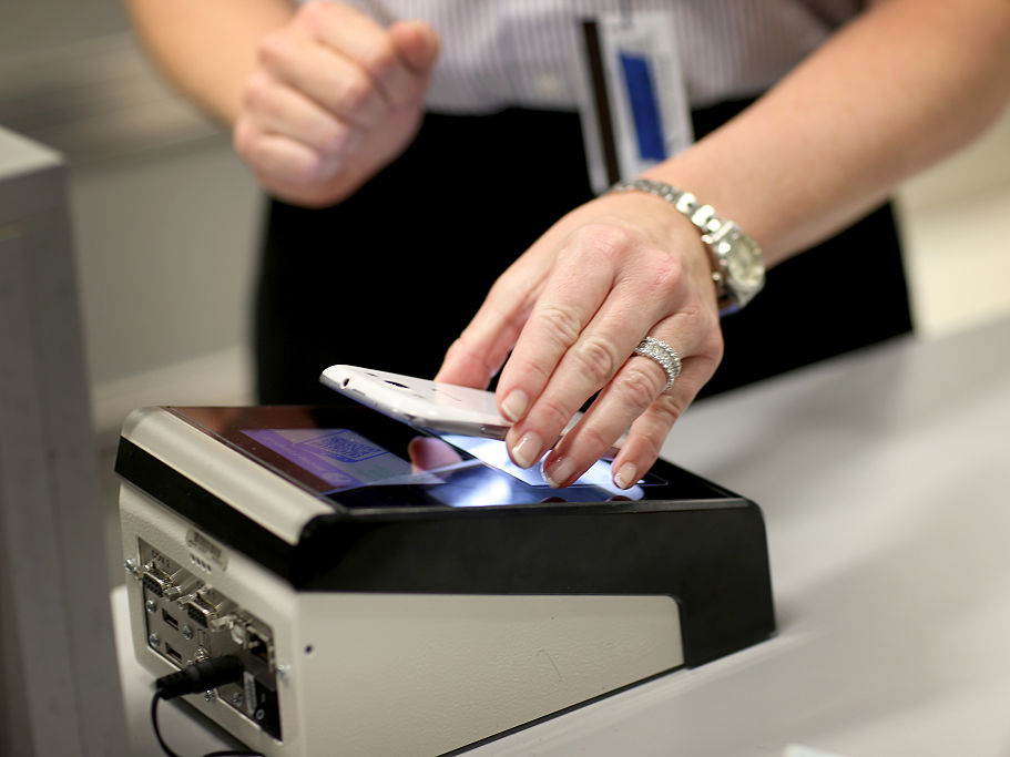 A passenger scans a mobile boarding pass at Miami International Airport in 2015