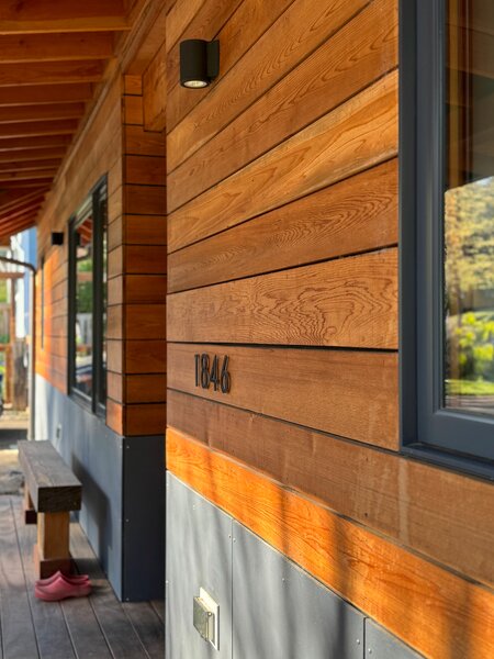 The renovated home is distinctive for its unpainted cedar cladding, paired with fiber-cement siding.