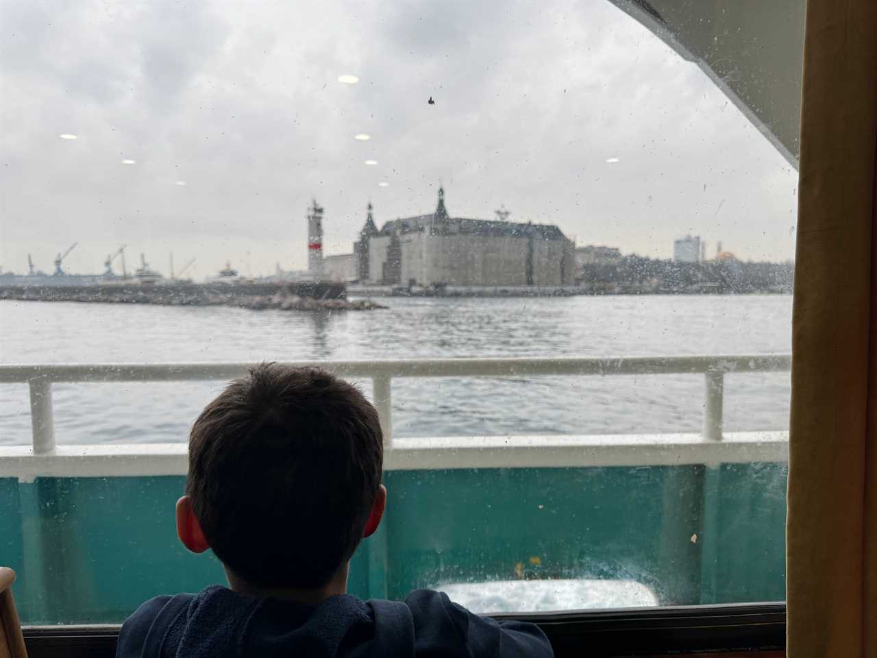 Boy looking at views of Istanbul from ferry window