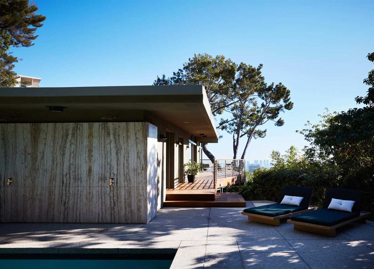 Concrete and travertine slabs were installed on the exterior, alongside an ipe deck with mahogany railings.