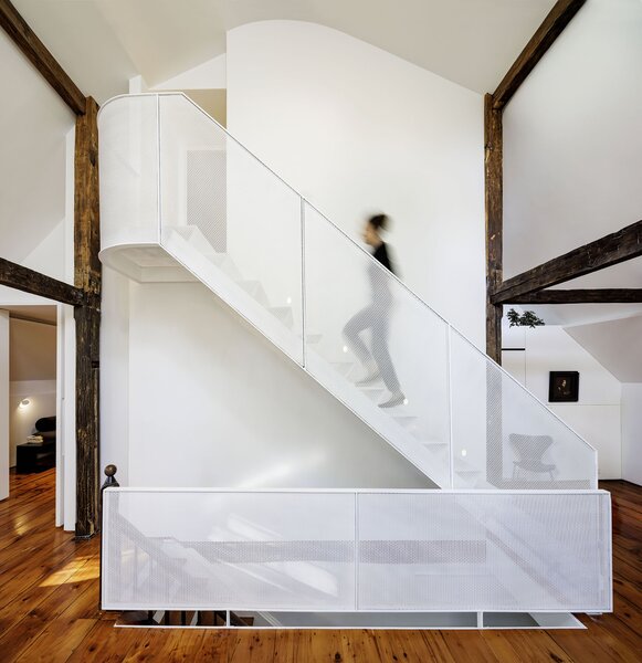 A cantilevered staircase with tread and railings composed of translucent steel mesh now connects the second and third floors.