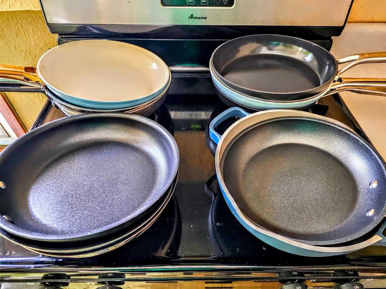 Several pans are displayed in four piles on a stove.