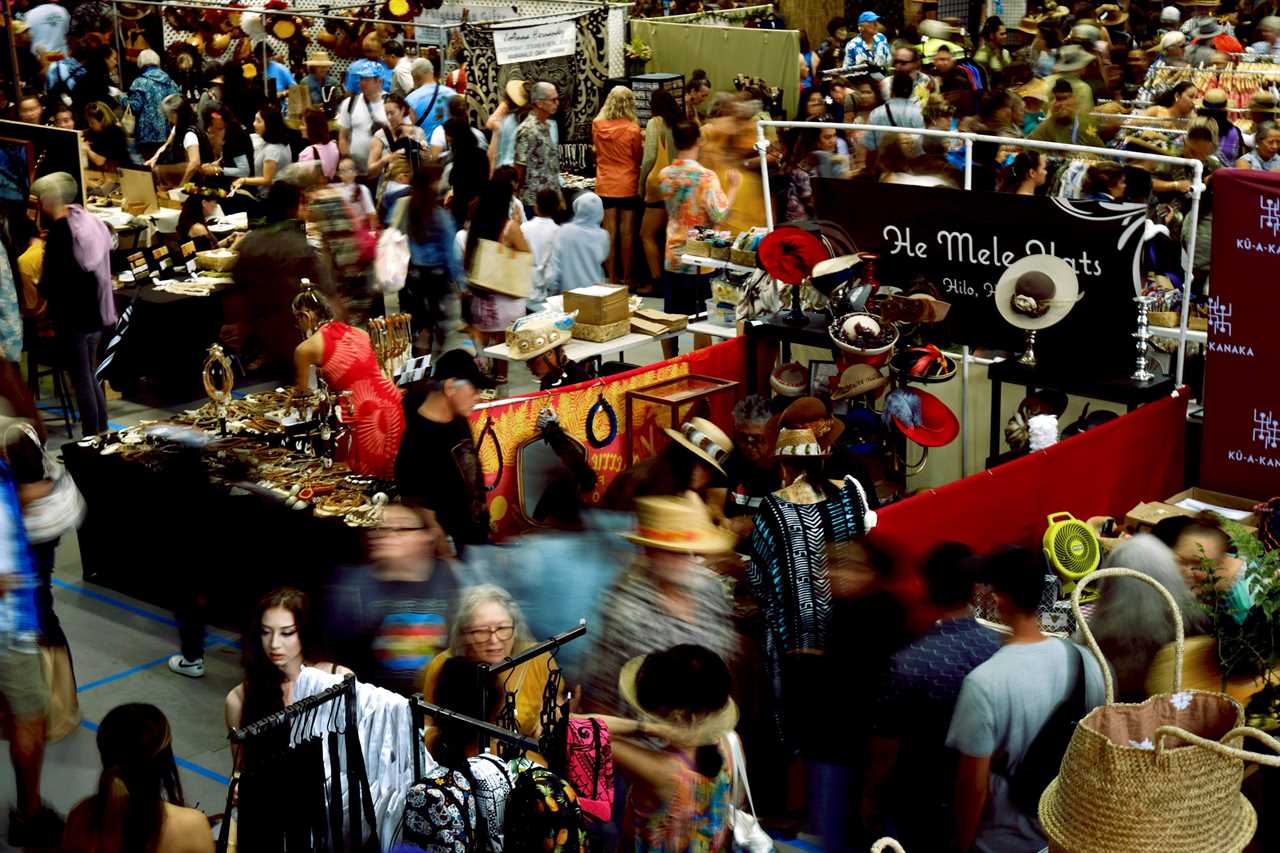 Inside a convention center with traditional Hawaiian artisan booths.