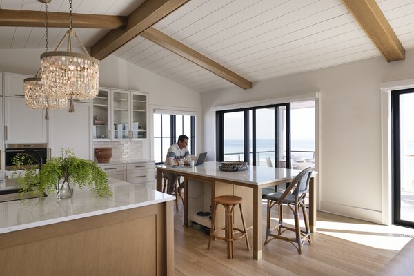 The home’s kitchen features white oak cabinets, beaded Ro Sham Beaux pendants, and even a custom feeding alcove for the couple’s dogs, complete with built-in pot filler to easily replenish water bowls throughout the day.