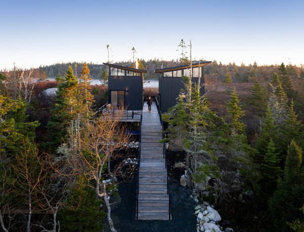 The pavilion closest to the road is the family’s sleeping quarters. It has a full bath, sleeping loft, and space for mechanical equipment. The second volume is a living space with a kitchenette finished in white oak, a lounge space with a wood-burning stove, and a sleeping loft for guests.