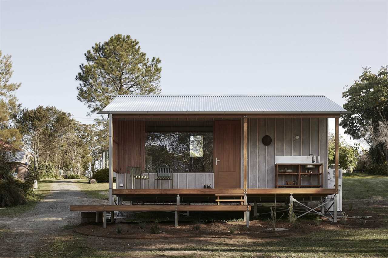 The design evokes a classic Australian miner's cottage with gable roof, veranda, and