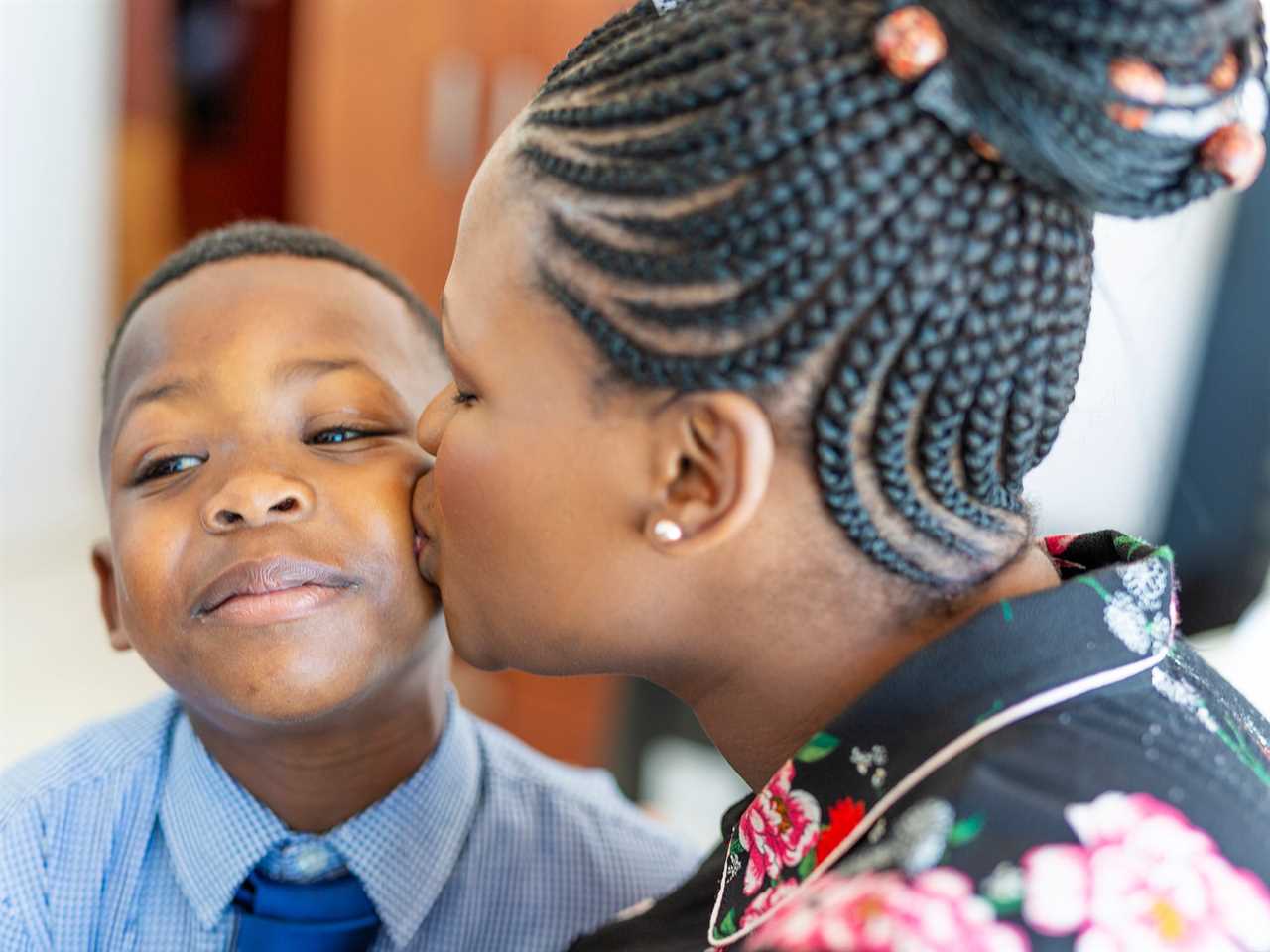 a woman kissing her son's cheek