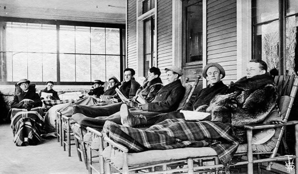 Before antibiotics, the standard treatment for tuberculosis was spending extended periods of time in the fresh, outdoor air. During winter, TB patients, like the ones seen here on a porch in Saranac Lake, rested in reclining 