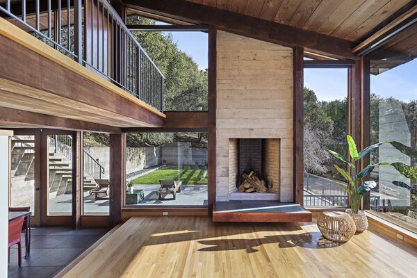 The main living room is anchored by a stone-and-brick fireplace and overlooks the side patio and lush lawn.